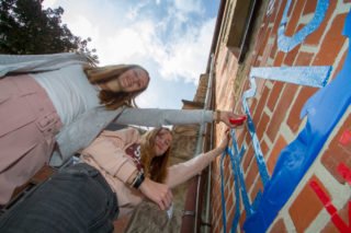 Die beiden 14-jährigen Engelsburg-Schülerinnen Emma Meyer und Anastasia Lopatta helfen mit, die Außenwand vor der Aula "demokratisch" zu gestalten. Foto: SMMP/Ulrich Bock